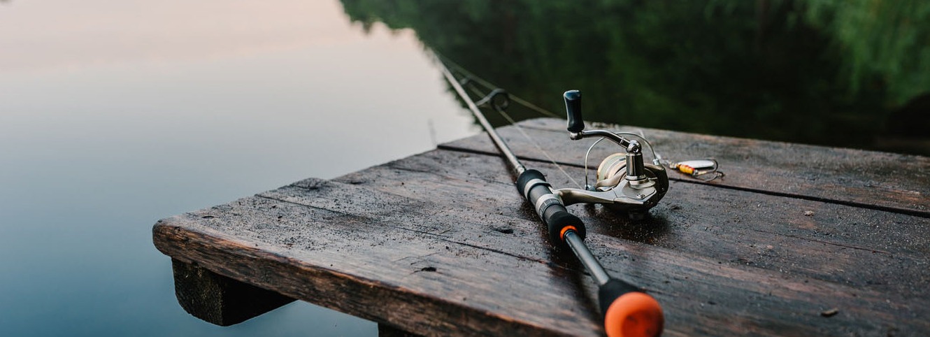 Fishing rod on fishing pier looking onto the water