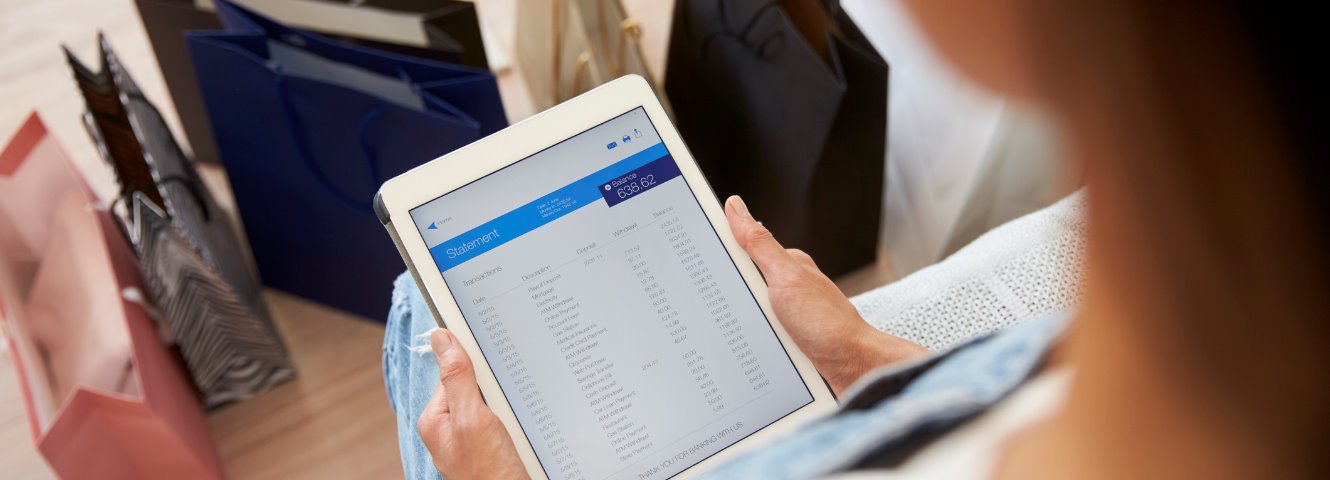 overhead looking down at woman reviewing a bank statement on an ipad